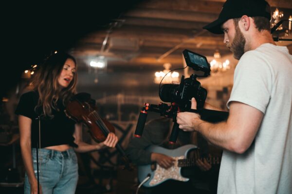 4font project news mężczyzna nagrywa kobietę grającą na skrzypcach w ciemnym pomieszczeniu