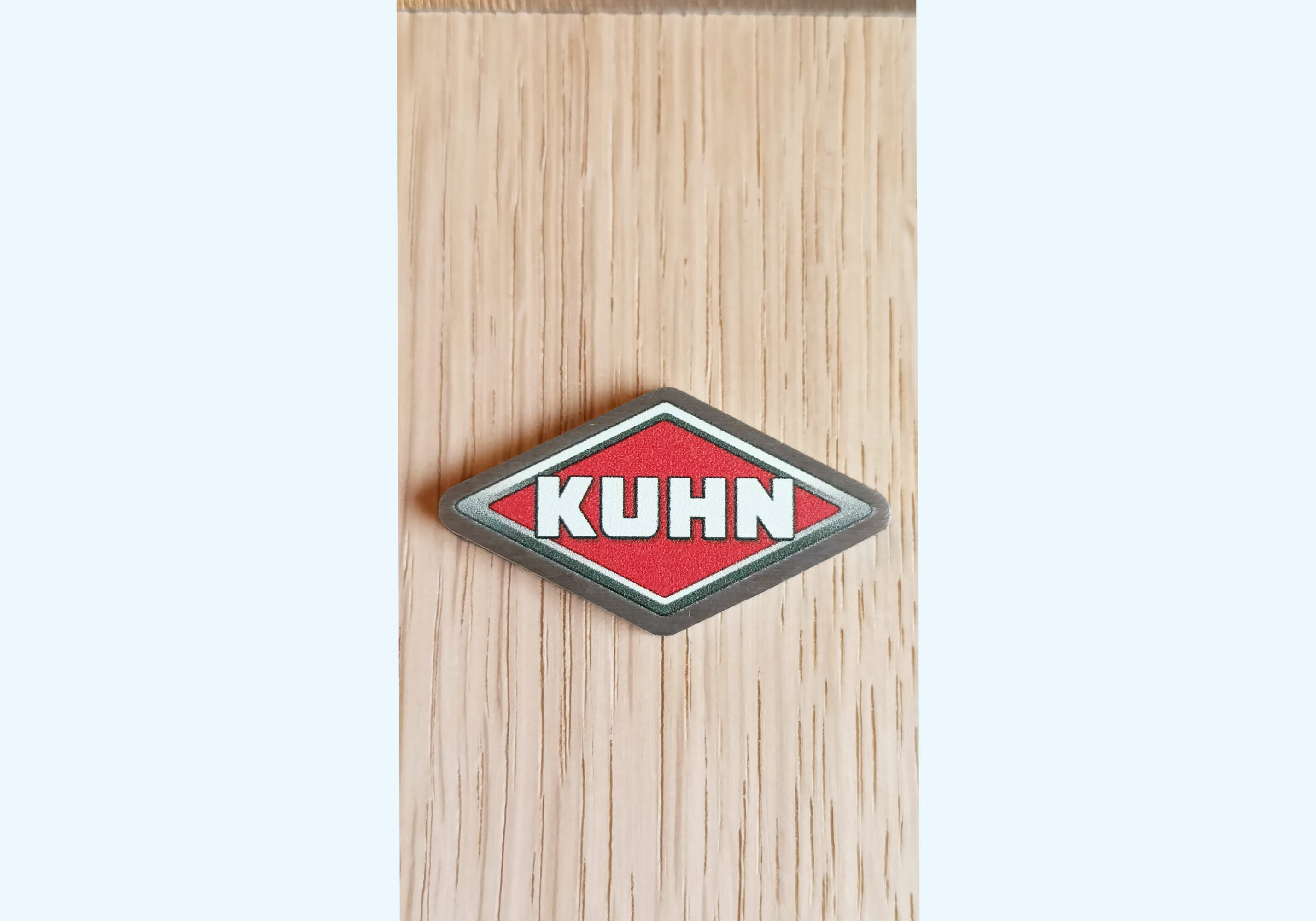 statuetka Kuhn detal loga